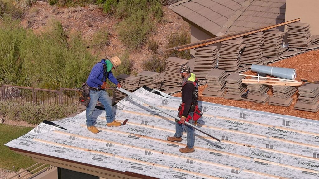 Tip Top Roofing Service crew installing new underlayment on a tile roof
