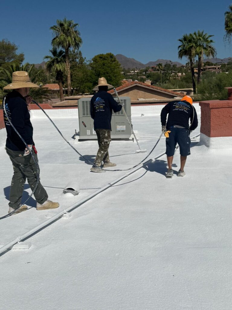 Tip Top Roofing Service crew on a freshly coated white flat roof